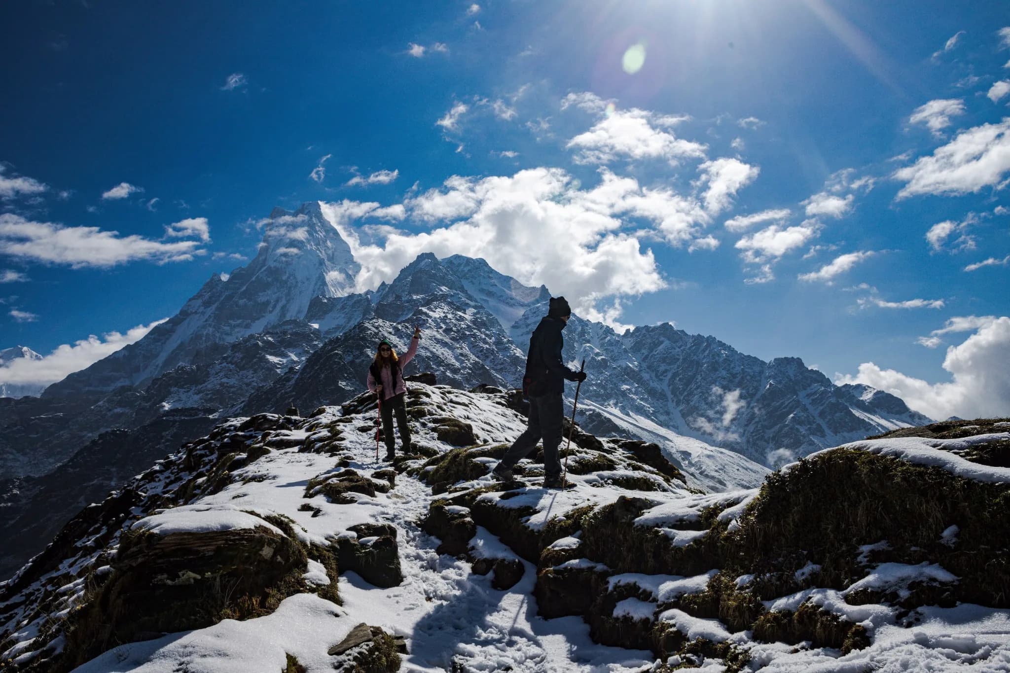 A stone-built mountain village below snow-capped peaks